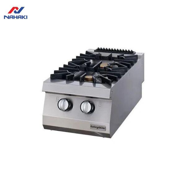 Kỹ thuật viên đang kiểm tra và bảo dưỡng bếp khè 3 họng bằng inox trong một khu bếp công nghiệp, nhấn mạnh tầm quan trọng của việc vệ sinh và an toàn.